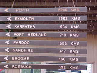 Sign reads: Perth 2240k, Exmouth 1502k, Karratha 934k, Port Hedland 710k, Pardoo 555k, Sandfire 417k, Broome 166k, Roebuck 132k