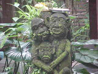 Statue of 3 monkeys; Mommy, Daddy and child.  There is a Hindu offering of food in a plate on their heads