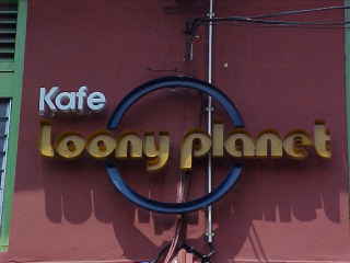 Mvc-158e-Resturant Kafe loony planet. Malacca, Malacca, Negeri Melaka, Malaysia: The Lonely Planet series of guidbooks is the de-facto standard amongst backpakers worldwide.  Many enterprising locals take advantage of this fact as this creative pun of a resturant name shows. (Malaysia, The Travel Addicts)