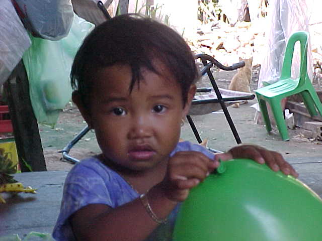 Smiley's daughter : Smiley's is the name of the guest house that we stayed in.  Most of the rooms were in a cinderblock row with tin roofs - Weather conditions in South East Asia in August are 99% humidity; 110°f.  Daytime ambient in these rooms rival that in a Mississippi BBQ pit.  We stayed in the baesment of Smiley's own house. (Cambodia, The Travel Addicts)