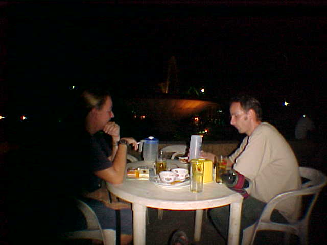 SGK and our friend Mike at dinner in front of that fountain (Laos, The Travel Addicts)