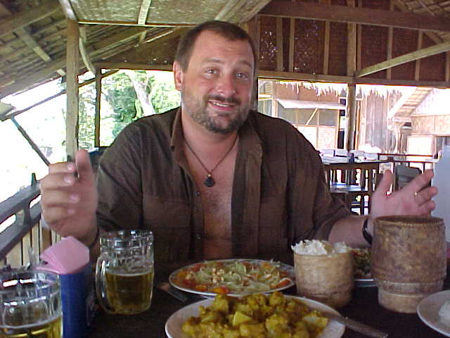 Michael enjoying Laap, Papaya salad, sticky rice, and pumpkin curry (Laos, The Travel Addicts)