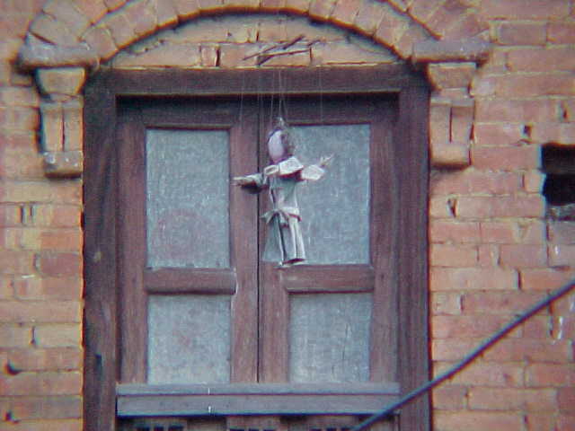 Dolls hanging from eaves (Nepal, The Travel Addicts)