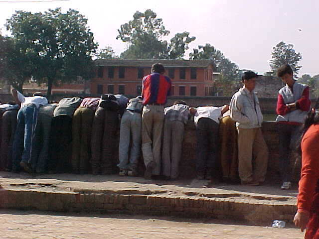 Looking at fish : I asked these gentlemen what they found so fascinating below this bridge.  "Fish" they answered (Nepal, The Travel Addicts)